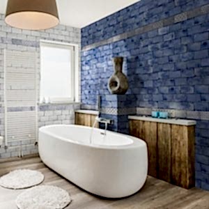 Vita Blue Brick Tiles on a bathroom wall/ Rounded white bathtub in front of wwoden panels.