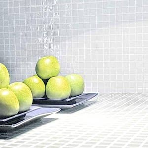 White mosaic tiles in a kitchen with plates of apples