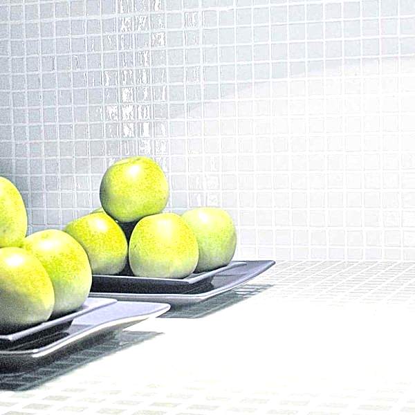 White mosaic tiles in a kitchen with plates of apples