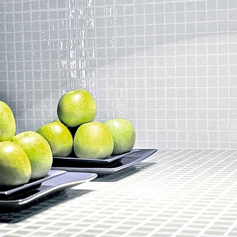 White mosaic tiles in a kitchen with plates of apples