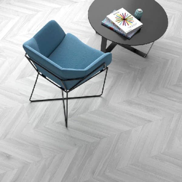 Ebony Grey Herringbone Tiles in a room setting with a blue armchair and small round black table
