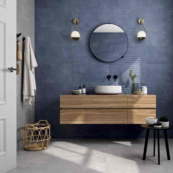 Eleganza Blue Ripple Tiles on a bathroom wall with a wooden unit and round mirror