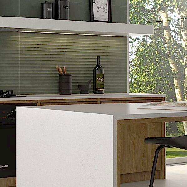 Photo of a kitchen breakfast bar with sage green ripple effect wall tiles behind the counter