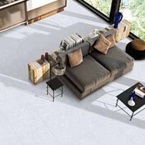 Blister Light Grey Stone Tiles in a bright living room setting with a modern grey sofa, beige cushions and stylish book-inspired decor.