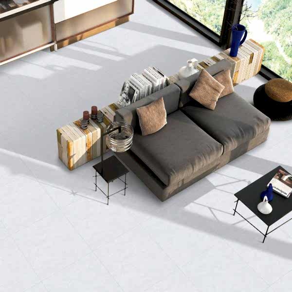Blister Light Grey Stone Tiles in a bright living room setting with a modern grey sofa, beige cushions and stylish book-inspired decor.